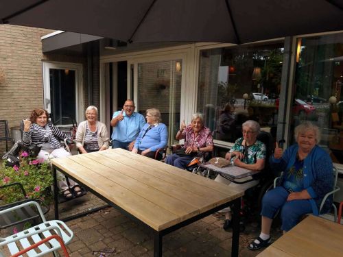 Foto van een groepje ouderen op het terras