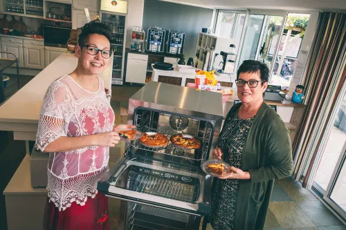 Twee vrouwewlijke collega's bij de oven.
