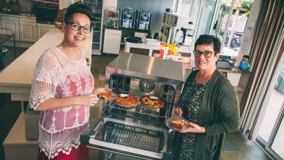 Twee vrouwewlijke collega's bij de oven. 