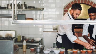 Moderne keuken waar twee medewerkers eten bereiden Moderne keuken waar twee medewerkers eten bereiden