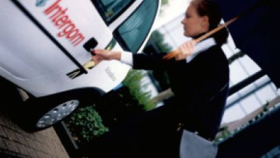 Medewerkster Intergom stap in haar auto Medewerkster Intergom stap in haar auto
