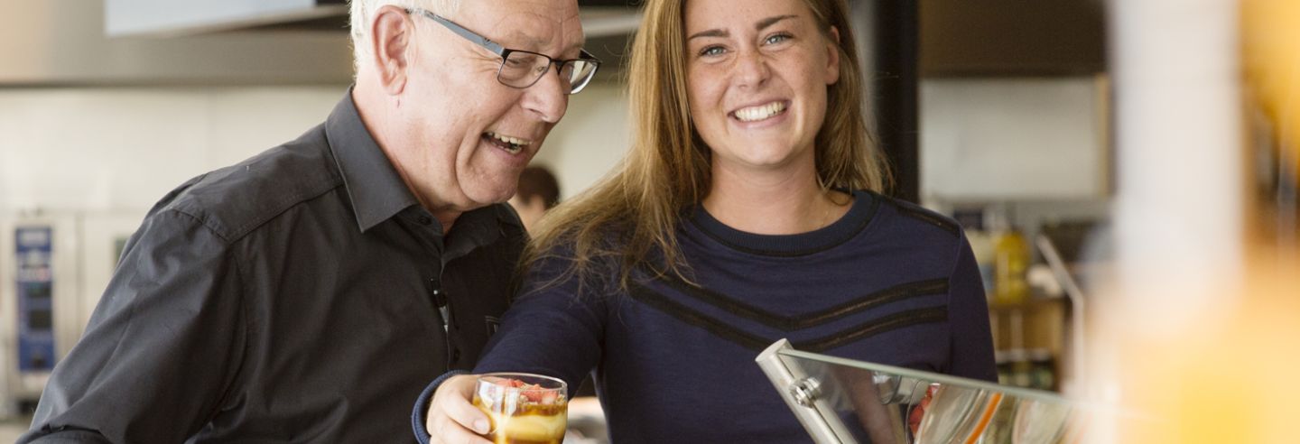 Man en vrouw in bedrijfskleding en samen op de werkplek