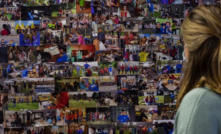 Diede Smit kijkt naar een fotobord met foto's van Stichting Grote Broer