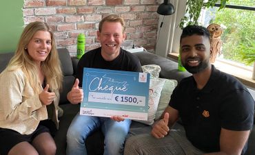 Twee management trainees van Facilicom reiken een cheque van 1500 euro uit aan de contactpersoon van Stichting Sterk en Positief.